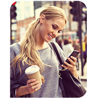 Woman holding a coffee, looking at her phone