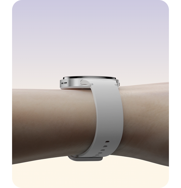 GLe bras d’une personne est étendu vers l’extérieur alors que la montre Galaxy Watch8 avec un bracelet sport blanc atterrit doucement et se fixe à son poignet.